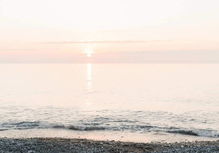 Peaceful shoreline at sunrise with soft waves and gentle light, representing clarity and awareness around emotional abuse warning signs.