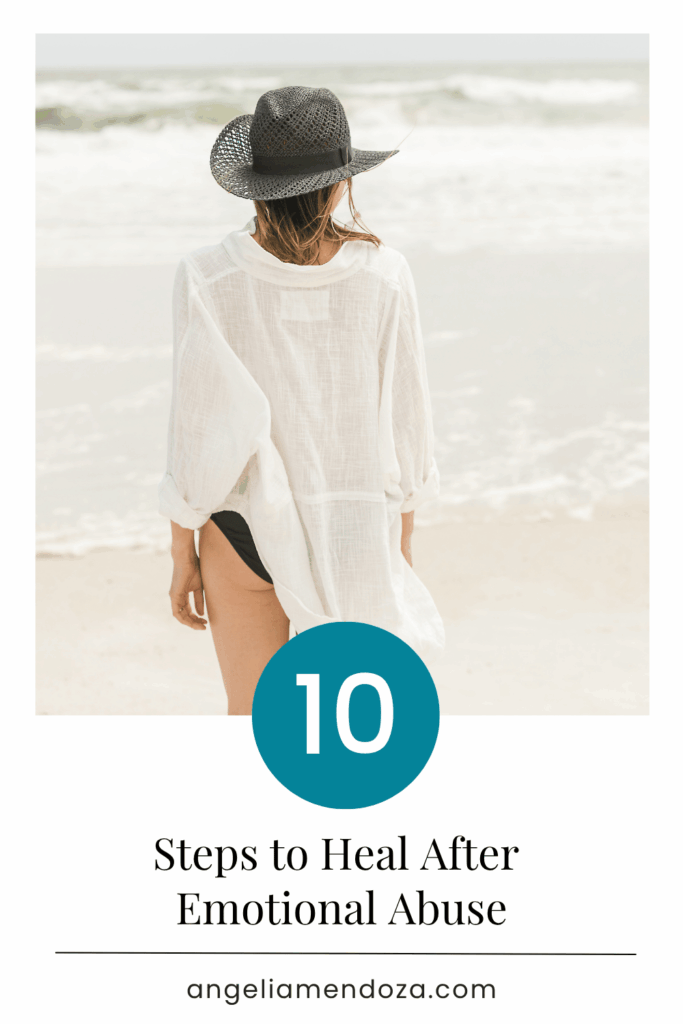 Calm beach scene with woman in white cover-up and hat walking by the ocean, symbolizing peace and recovery after emotional abuse.