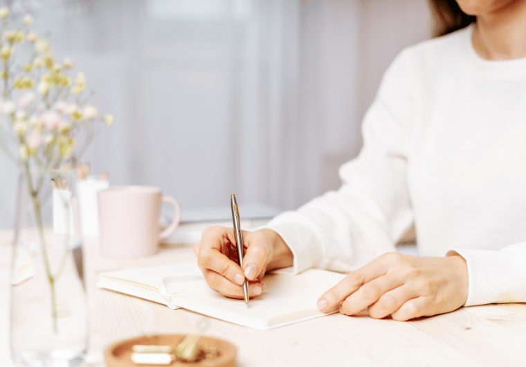 Midlife woman journaling daily affirmations at a cozy desk | Angelia Mendoza